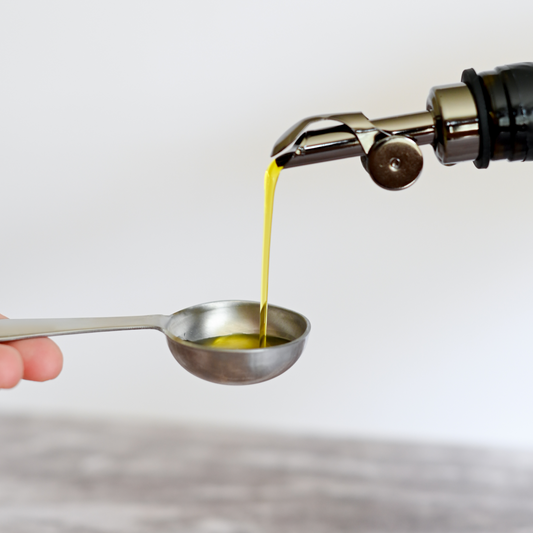 pouring extra virgin olive oil into a measuring spoon